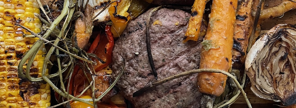 leftover food from a BBQ, burger, corn, carrots