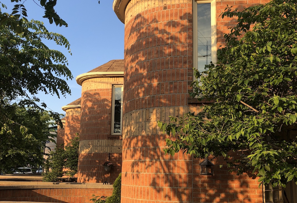 an orange brick home with the sun shining on it